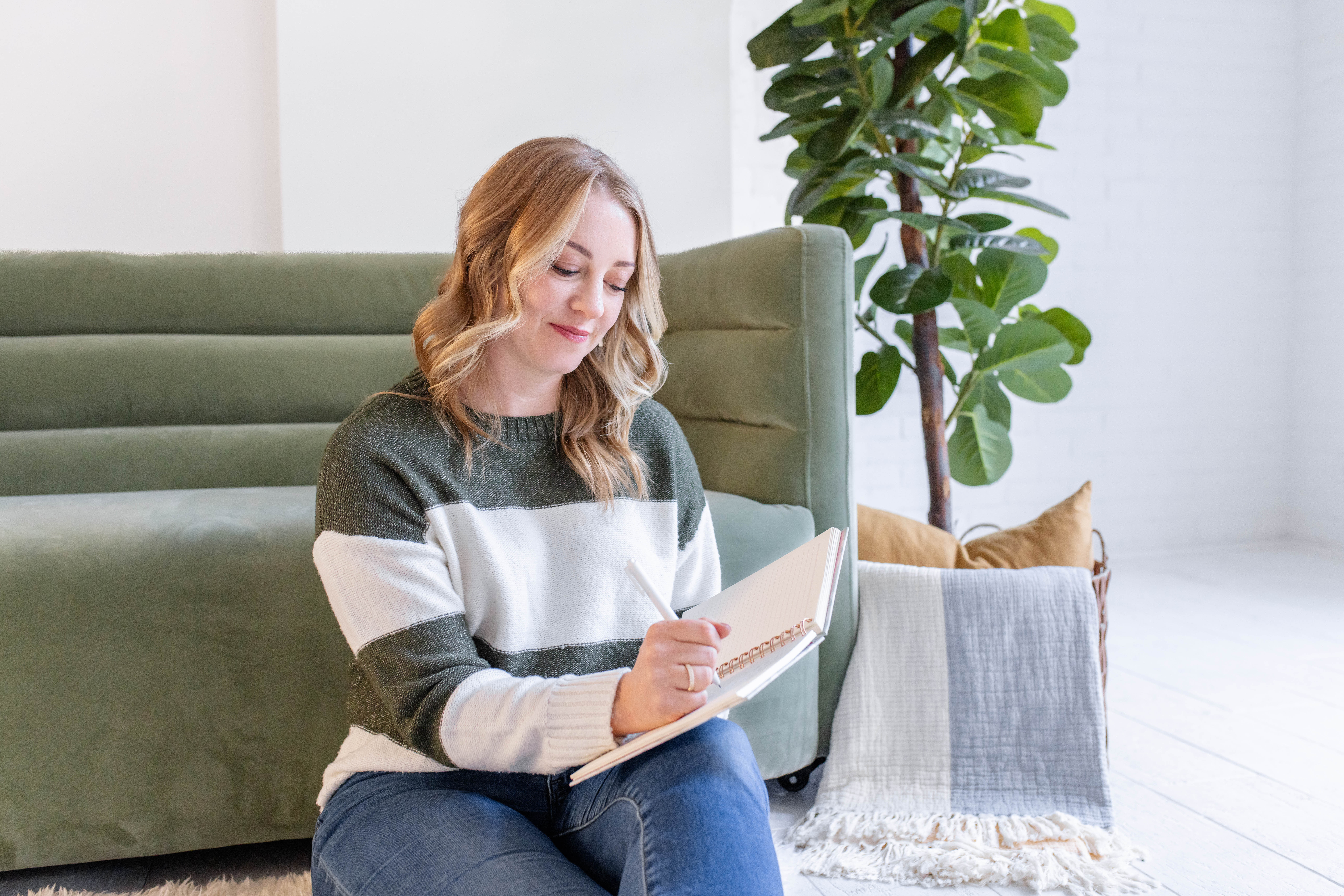 Krysteena Wilson writing in a journal. Private Practice Coach for Therapists